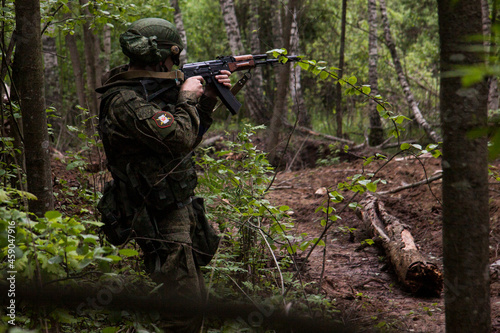 A soldier with a machine gun is aiming in the thicket. Russian Army