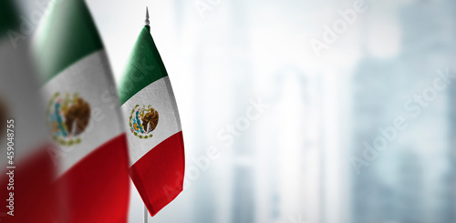 Small flags of Mexico on a blurry background of the city photo