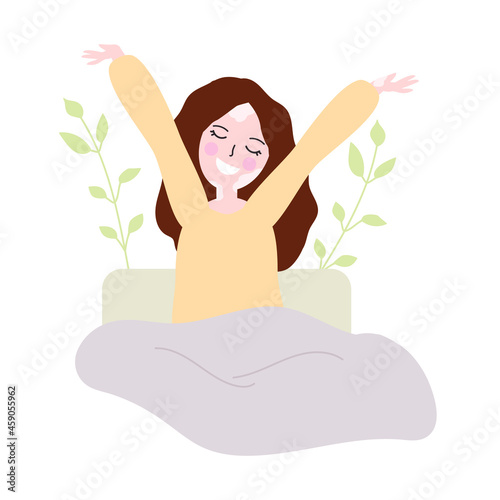 Girl, woman with vitiligo wakes up and stretches in bed under the covers in bed.