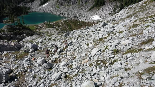 Hikers and their dog exploring the backcountry with watersprite lake in the background. Squamish BC, Canada photo