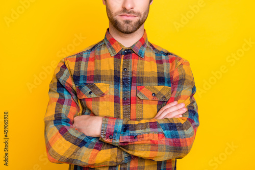 Photo of pretty serious young guy dressed checkered shirt arms crossed isolated yellow color background