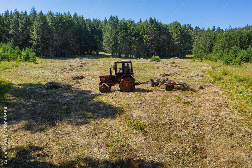 Obraz premium Southern Urals. Mountain meadow. Tractor on the hayfield. Aerial view.