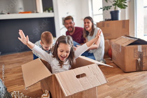 A young family is playing in the new home they have just moved in. Home, family, moving
