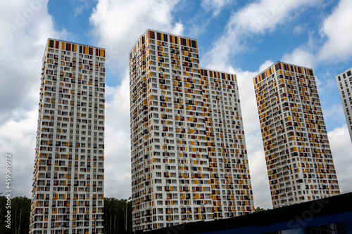 blue sky with clouds through the beautiful geometry of residential high-rise buildings 