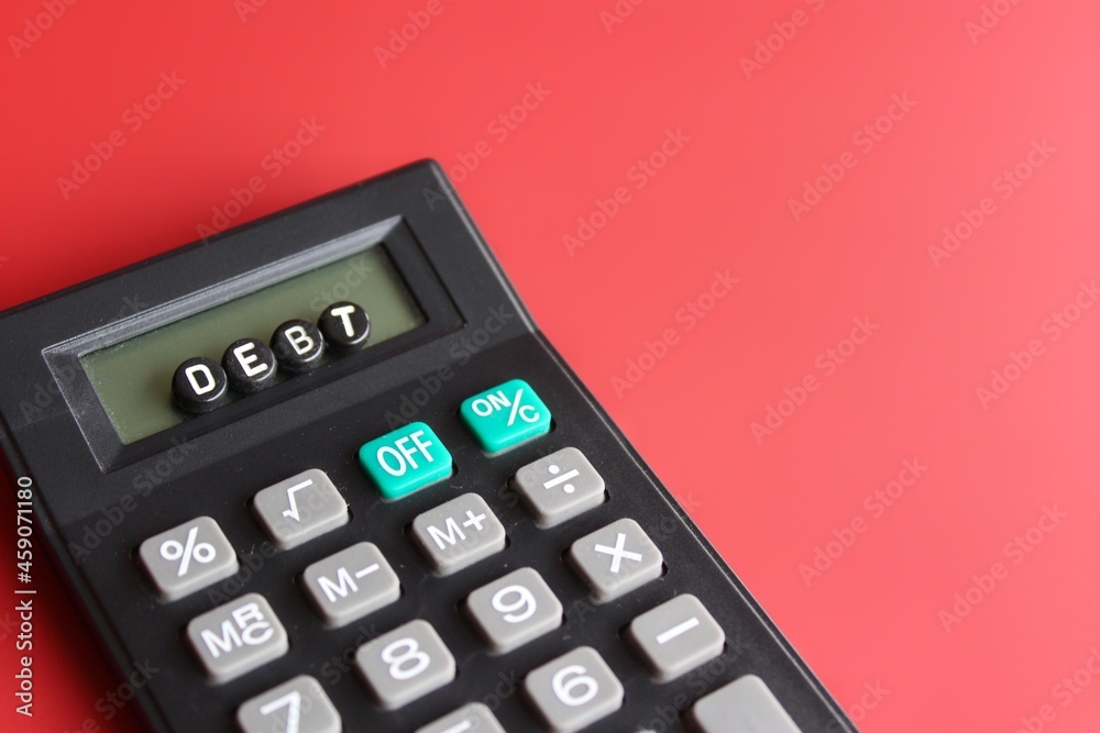 Business and finance concept. Calculator and alphabet beads with text DEBT. Business and finance concept. Calculator and alphabet beads with text DEBT.