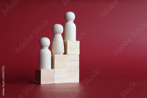 Selective focus image of wooden doll stand on staircase ladder with copy space. Growth, success and leadership concept
