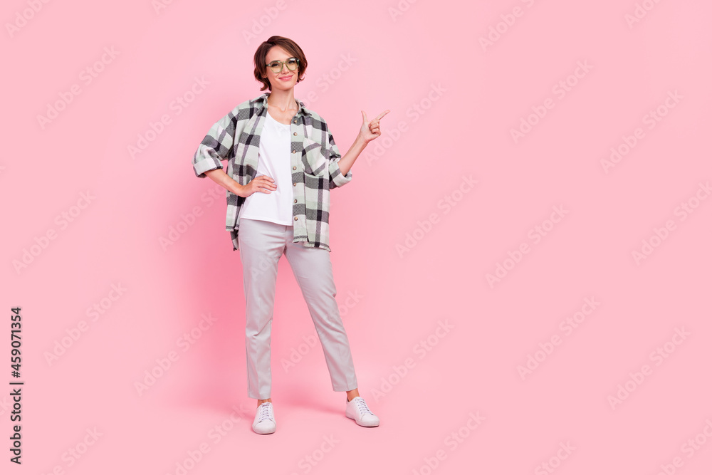 Full length photo of funny millennial brunette lady point wear eyewear shirt trousers sneakers isolated on pink background Full length photo of funny millennial brunette lady point wear eyewear shirt trousers sneakers isolated on pink background