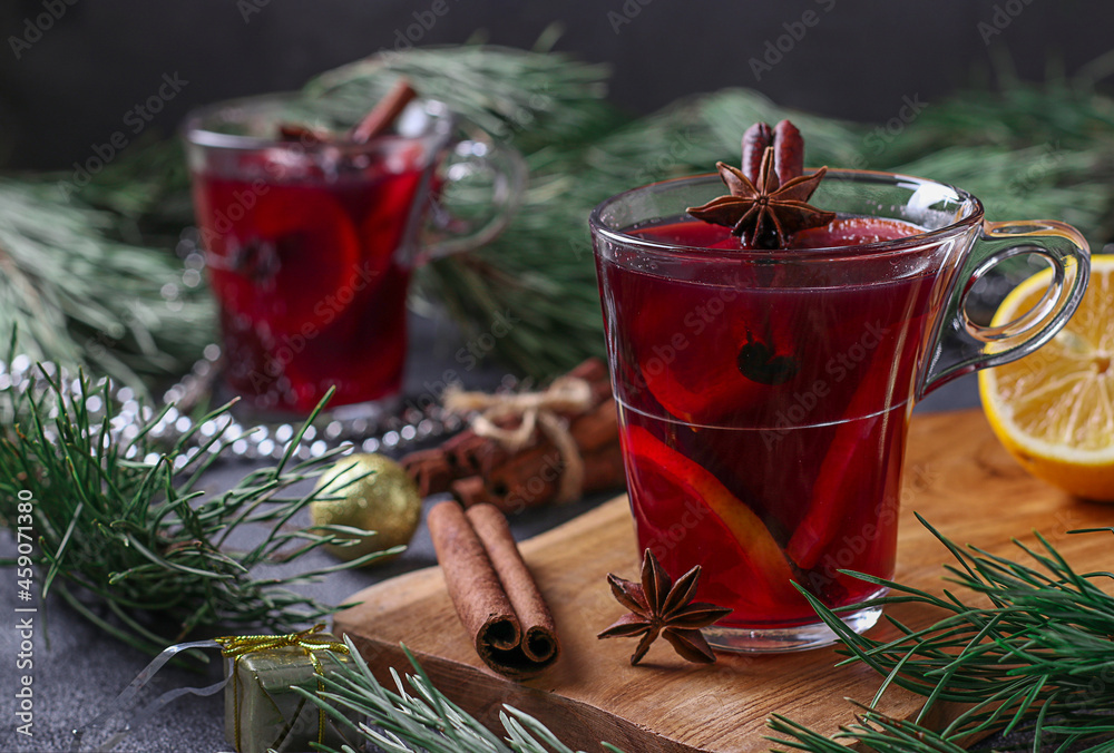 Christmas mulled wine in two glass cups on a wooden board on dark background Christmas mulled wine in two glass cups on a wooden board on dark background