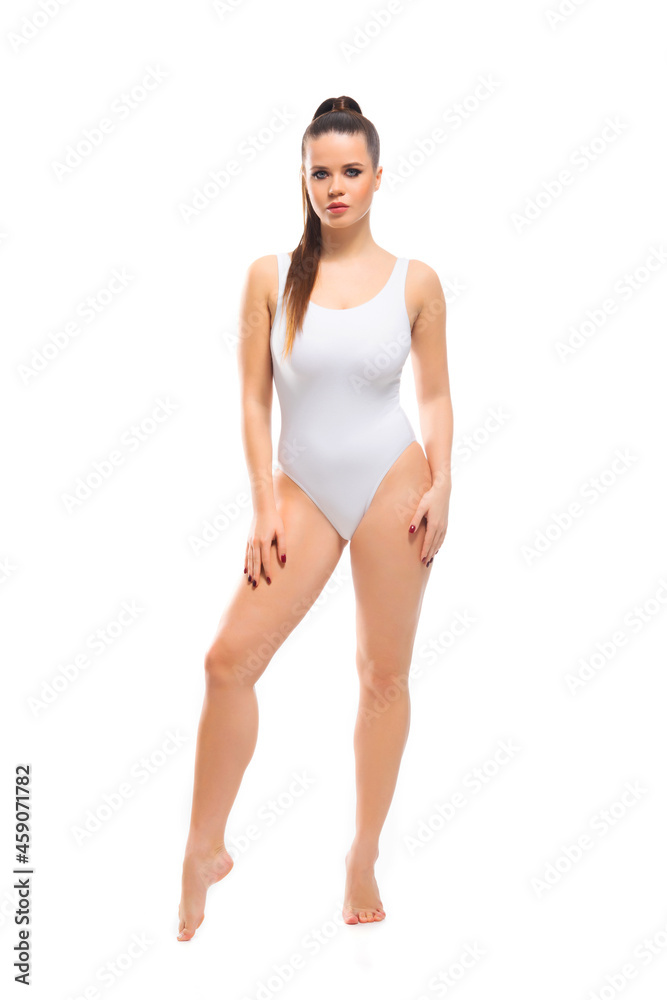 Fototapeta premium Young, fit and beautiful brunette woman in white swimsuit isolated on white background. Healthcare, diet, sport and fitness.