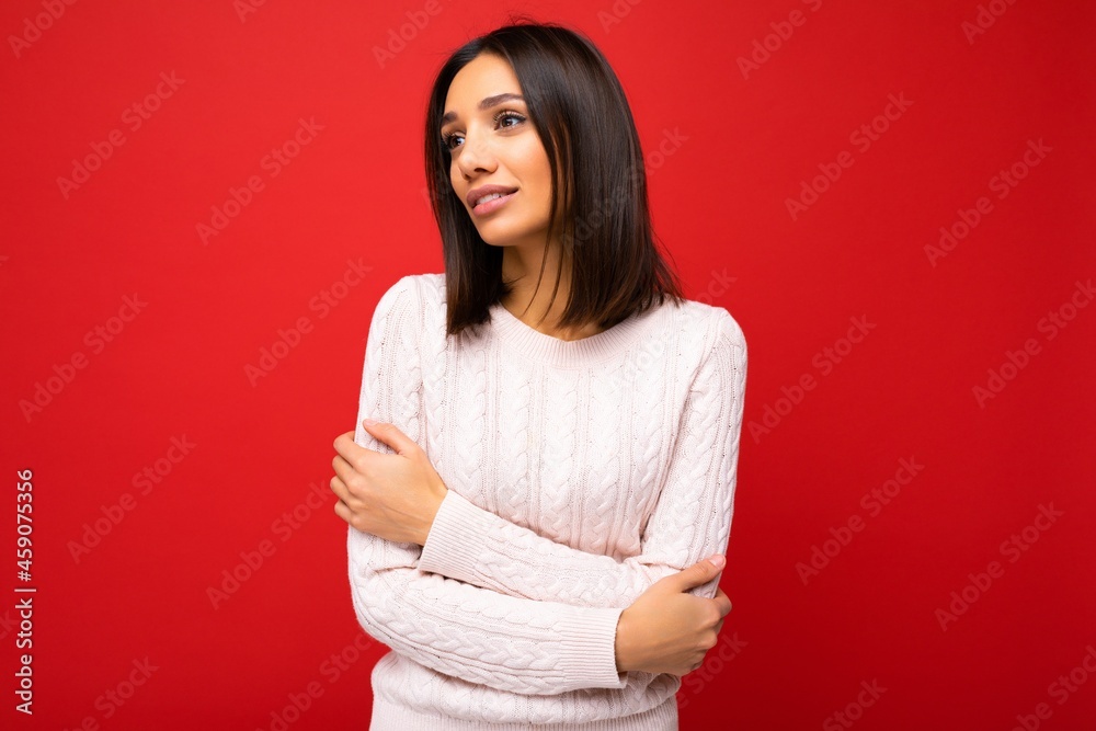 Beautiful cute nice adorable young brunet woman in stylish light knitted jersey isolated over red background wall with free space and enjoying Beautiful cute nice adorable young brunet woman in stylish light knitted jersey isolated over red background wall with free space and enjoying