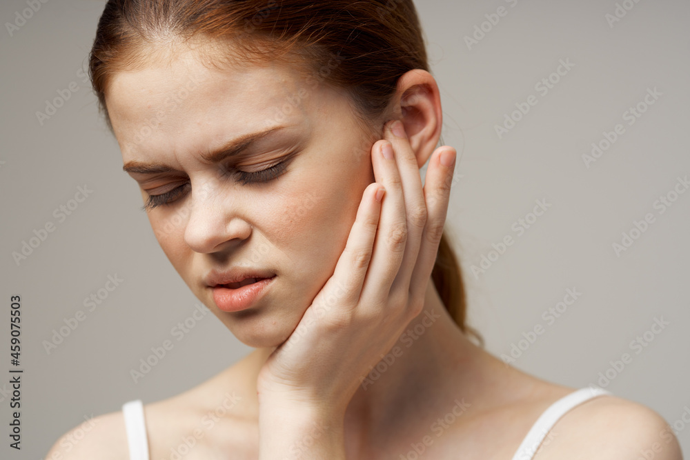 sick woman poor hearing disorders in white t-shirts light background sick woman poor hearing disorders in white t-shirts light background