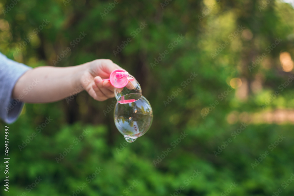 Soap bubble on a stick in the hands of a child