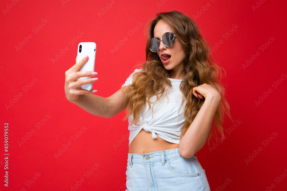 Sexy amazing beautiful young woman holding mobile phone taking selfie photo using smartphone