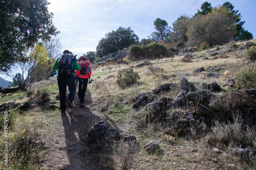 hikers climb a slope in Sierra de Huetor in autumn