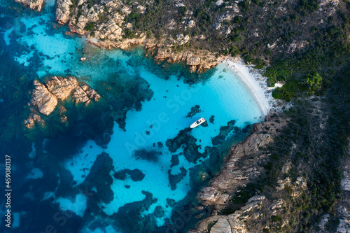 Fototapeta Naklejka Na Ścianę i Meble -  View from above, stunning aerial view of Mortorio island with a beautiful white sand beach and a boat floating on a turquoise water. Sardinia, Italy.