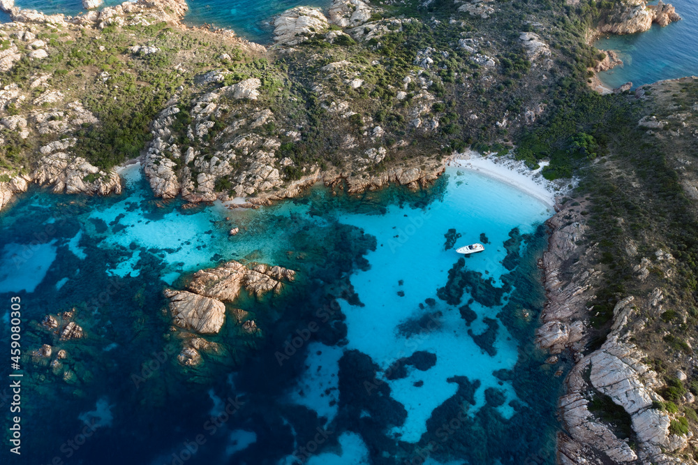 Fototapeta premium View from above, stunning aerial view of Mortorio island with a beautiful white sand beach and a boat floating on a turquoise water. Sardinia, Italy.