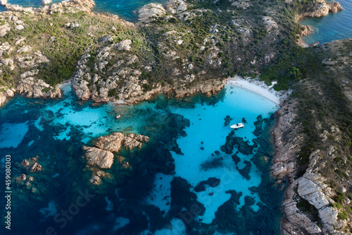 View from above, stunning aerial view of Mortorio island with a beautiful white sand beach and a boat floating on a turquoise water. Sardinia, Italy.