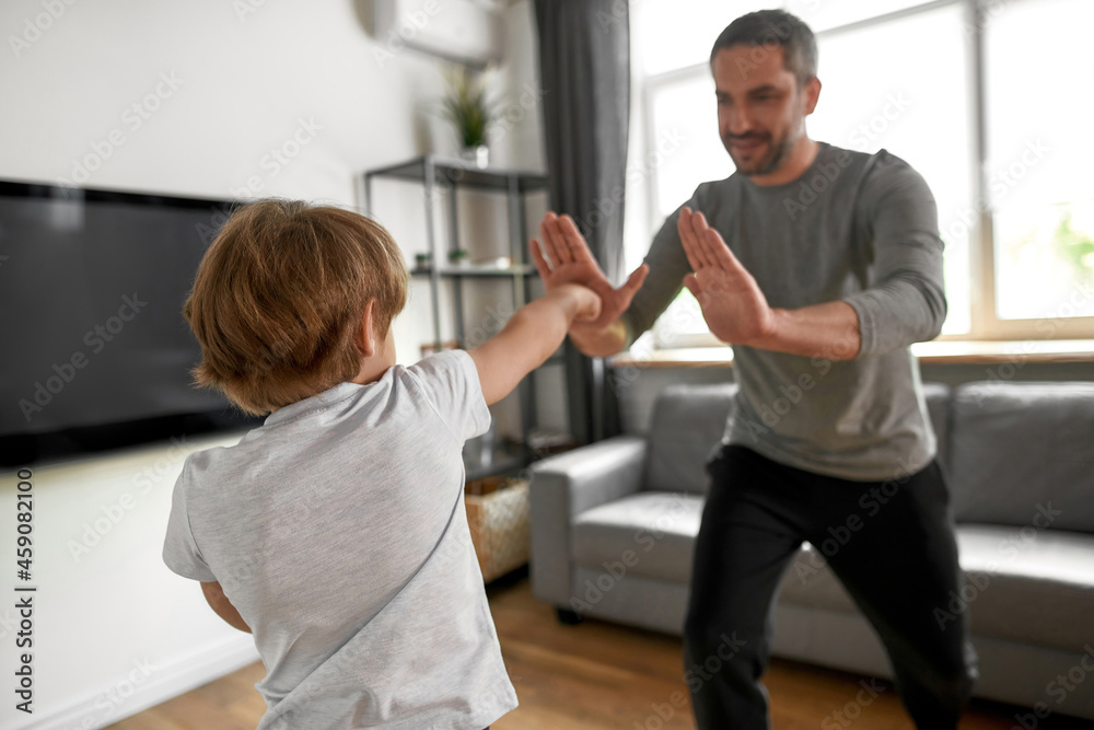 Sporty teen boy child have workout with dad at home Sporty teen boy child have workout with dad at home