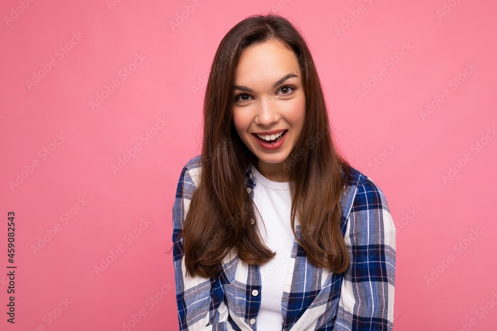 Photo portrait of young beautiful smiling hipster brunette woman in trendy blue and white shirt and jeans clothes. Sexy carefree female person posing isolated near pink wall with empty space in studio Photo portrait of young beautiful smiling hipster brunette woman in trendy blue and white shirt and jeans clothes. Sexy carefree female person posing isolated near pink wall with empty space in studio