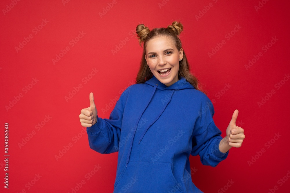 Photo of young positive happy smiling beautiful woman with sincere emotions wearing stylish clothes isolated over background with copy space and showing thumbs up Photo of young positive happy smiling beautiful woman with sincere emotions wearing stylish clothes isolated over background with copy space and showing thumbs up