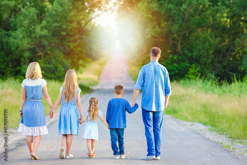 A Happy family walk along the road in the park on nature background