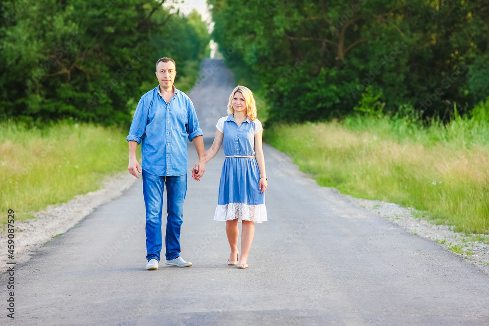 A Happy couple walking on the road in nature in the park A Happy couple walking on the road in nature in the park