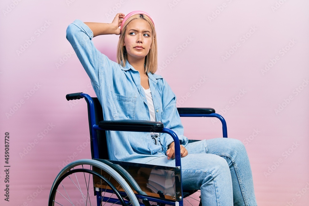 Beautiful blonde woman sitting on wheelchair confuse and wondering about question. uncertain with doubt, thinking with hand on head. pensive concept. Beautiful blonde woman sitting on wheelchair confuse and wondering about question. uncertain with doubt, thinking with hand on head. pensive concept.