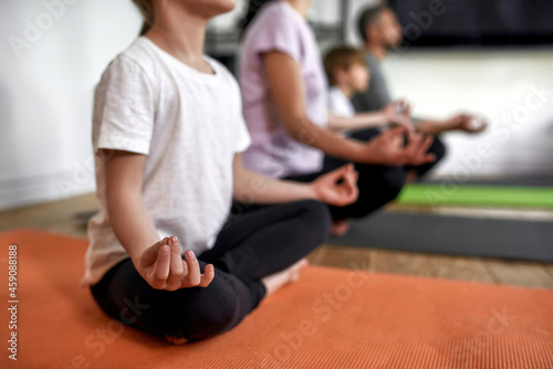 Crop of family with kids meditate at home together