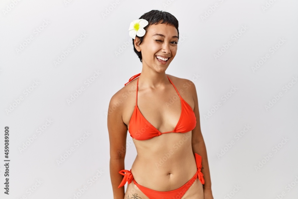 Young hispanic woman with short hair wearing bikini winking looking at the  camera with sexy expression, cheerful and happy face. Stock Photo | Adobe  Stock