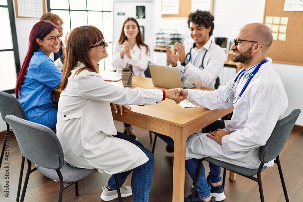 Group of doctor smiling and clapping to partners handshake in a medical meeting at the clinic office. Group of doctor smiling and clapping to partners handshake in a medical meeting at the clinic office.