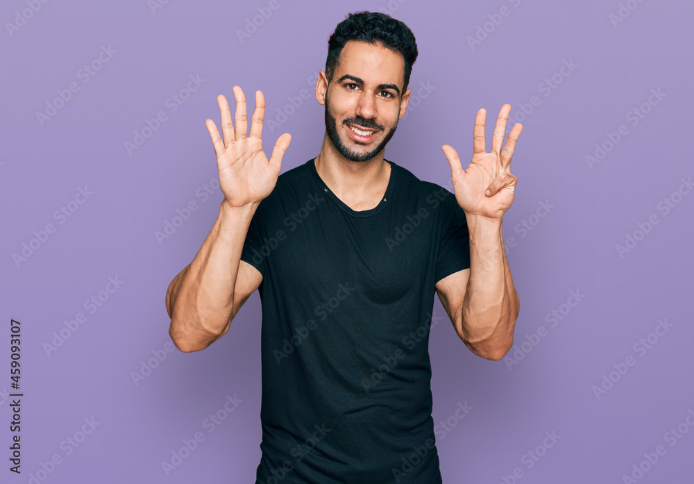 Hispanic man with beard wearing casual black t shirt showing and pointing up with fingers number nine while smiling confident and happy. Hispanic man with beard wearing casual black t shirt showing and pointing up with fingers number nine while smiling confident and happy.