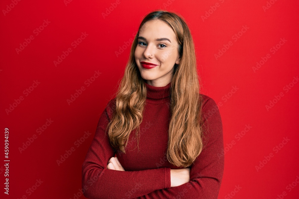 Young blonde woman wearing turtleneck sweater happy face smiling with crossed arms looking at the camera. positive person. Young blonde woman wearing turtleneck sweater happy face smiling with crossed arms looking at the camera. positive person.