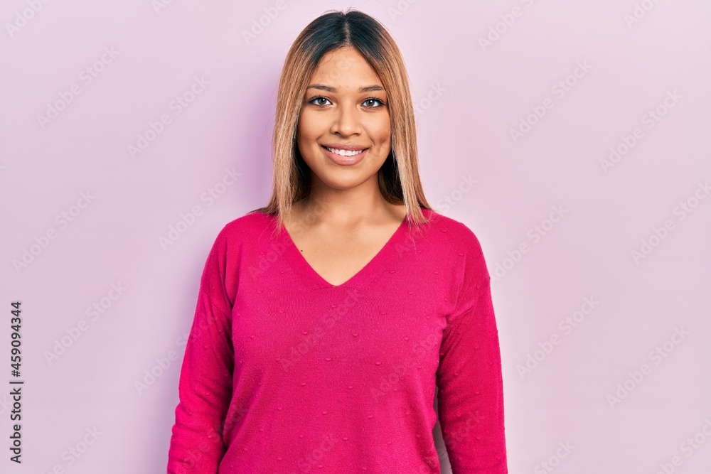 Fototapeta premium Beautiful hispanic woman wearing casual pink sweater with a happy and cool smile on face. lucky person.