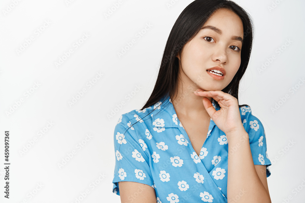 Portrait of beautiful asian girl with dark long hair, healthy glowing skin, gazing tender at camera, standing over white background Portrait of beautiful asian girl with dark long hair, healthy glowing skin, gazing tender at camera, standing over white background