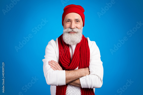 Photo of sweet cute age gentleman wear white sweater red headwear arm crossed smiling isolated blue color background