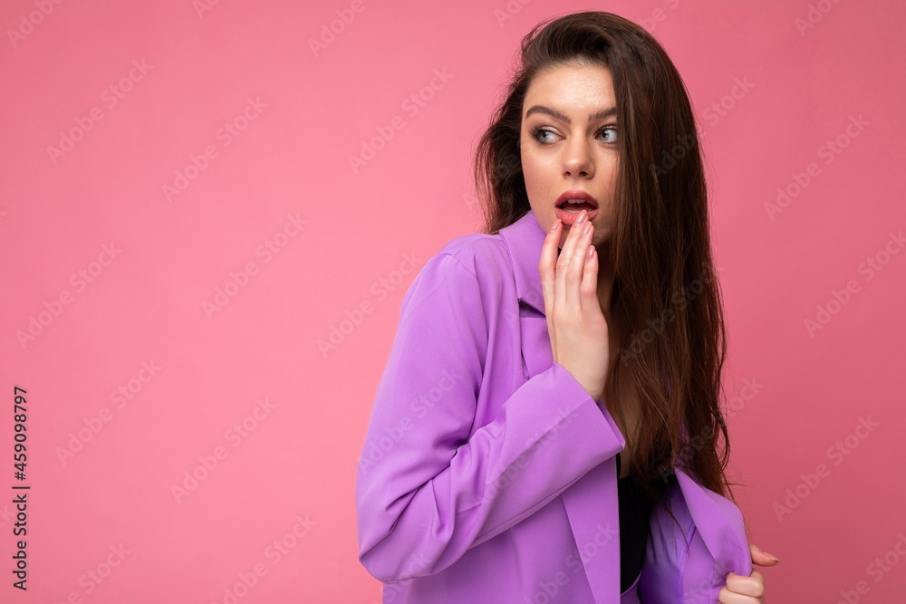 Adult shocked amazed brunet female person beautiful fashionable wearing trendy purple jacket isolated on pink background with free space Adult shocked amazed brunet female person beautiful fashionable wearing trendy purple jacket isolated on pink background with free space