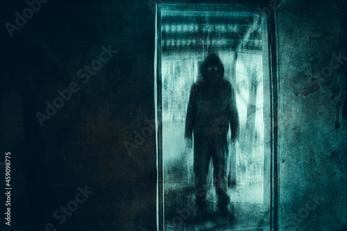A dark scary concept. Of a mysterious demon figure, with glowing eyes standing in a doorway of an abandoned house. With a grunge, textured edit.