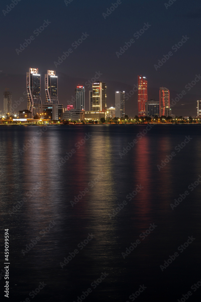 Izmir, Turkey - September 21, 2021: Night view from the sea of the new skyscrapers district of Izmir city. Izmir is Turkey's third largest city.