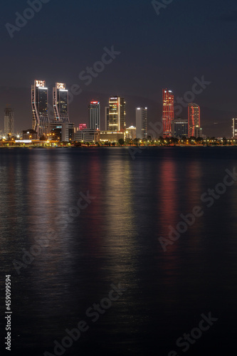 Izmir, Turkey - September 21, 2021: Night view from the sea of the new skyscrapers district of Izmir city. Izmir is Turkey's third largest city.