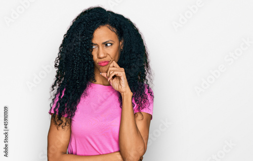 Middle age african american woman wearing casual clothes serious face thinking about question with hand on chin, thoughtful about confusing idea