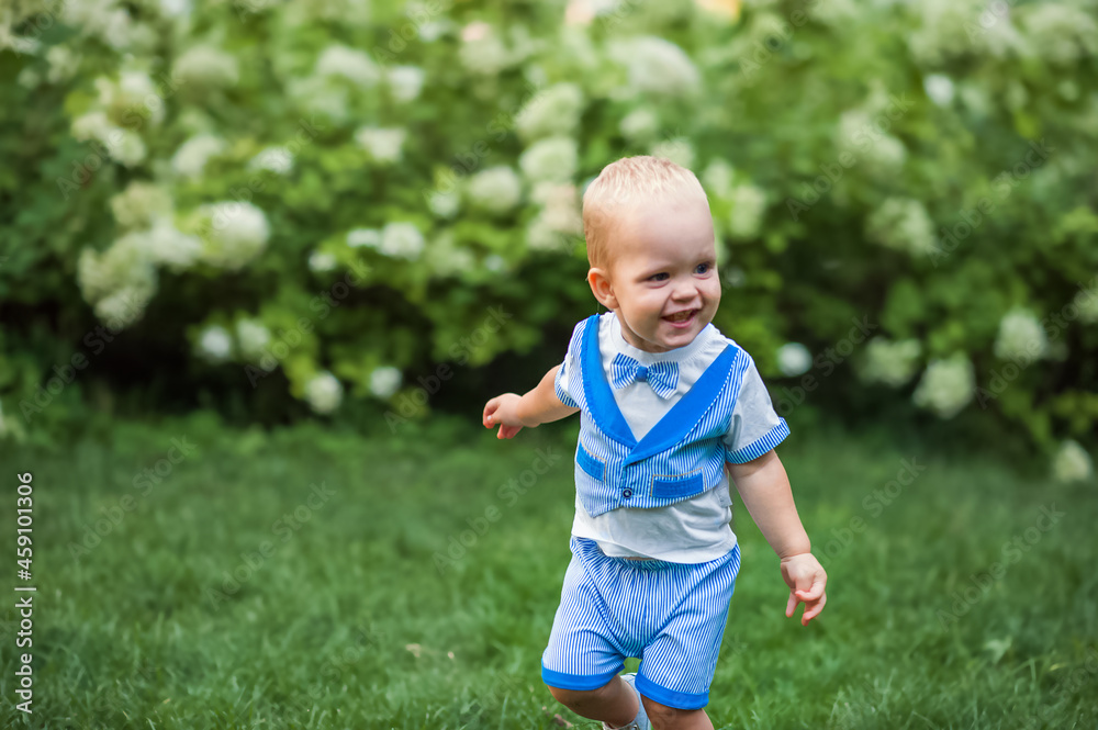 Happy little toddler boy in suit running on lawn close-up and copy space... Happy little toddler boy in suit running on lawn close-up and copy space...