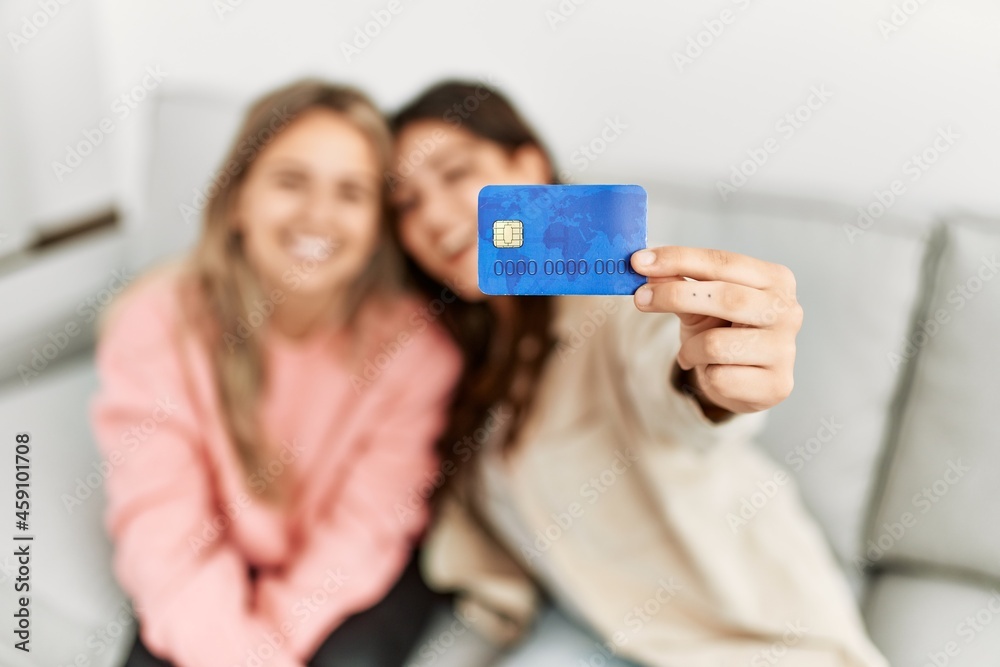 Young couple smiling happy holding credit card at home. Young couple smiling happy holding credit card at home.