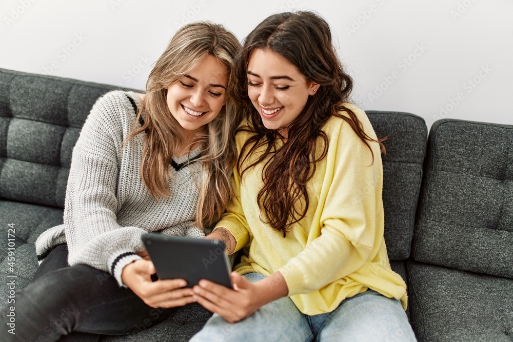 Young couple smiling happy using touchpad at home. Young couple smiling happy using touchpad at home.