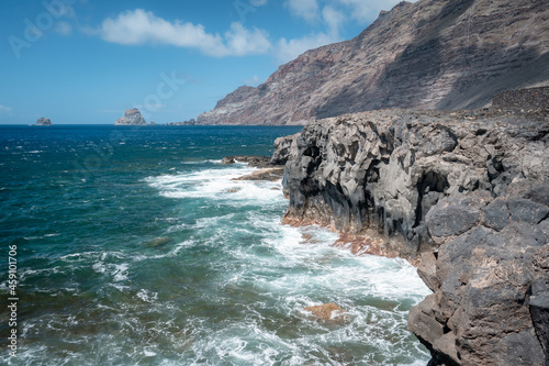 Volcanic cliff in Las Puntas with Salmor Rocks in the background. El Hierro island. Canary Islands photo