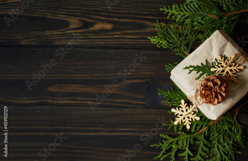Zero Waste Christmas concept. Eco friendly Christmas composition with gift box in craft reusable paper, natural decor and candle on wooden background. copy space