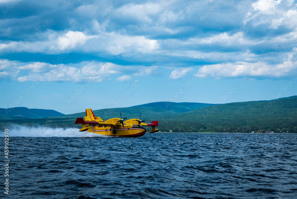 Fototapeta premium Canadair CL-415 water bomber working to extinguishe a forest fire in eastern Quebec, Canada.
