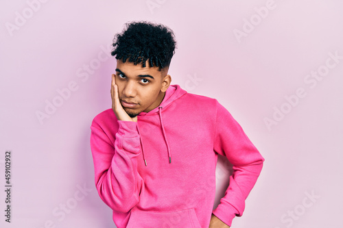 Young african american man wearing casual sweatshirt thinking looking tired and bored with depression problems with crossed arms.