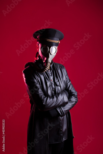 fantastic Nazi in black leather clothes and a cap with a gas mask on face, photo