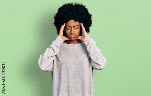 Young african american woman wearing casual clothes with hand on head for pain in head because stress. suffering migraine. © Krakenimages.com