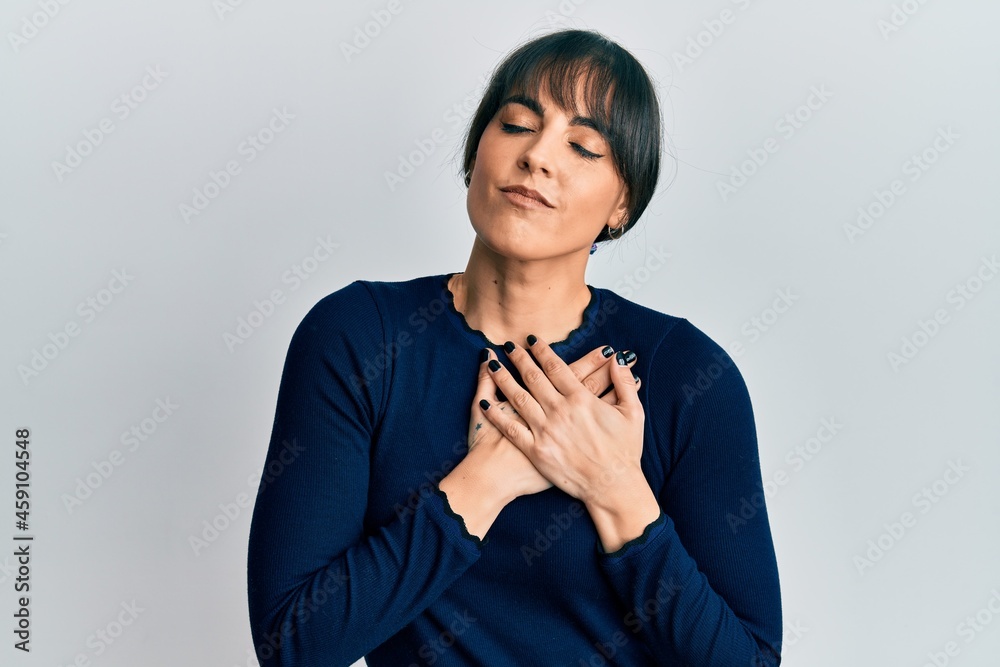 Young hispanic woman wearing casual clothes smiling with hands on chest, eyes closed with grateful gesture on face. health concept. Young hispanic woman wearing casual clothes smiling with hands on chest, eyes closed with grateful gesture on face. health concept.